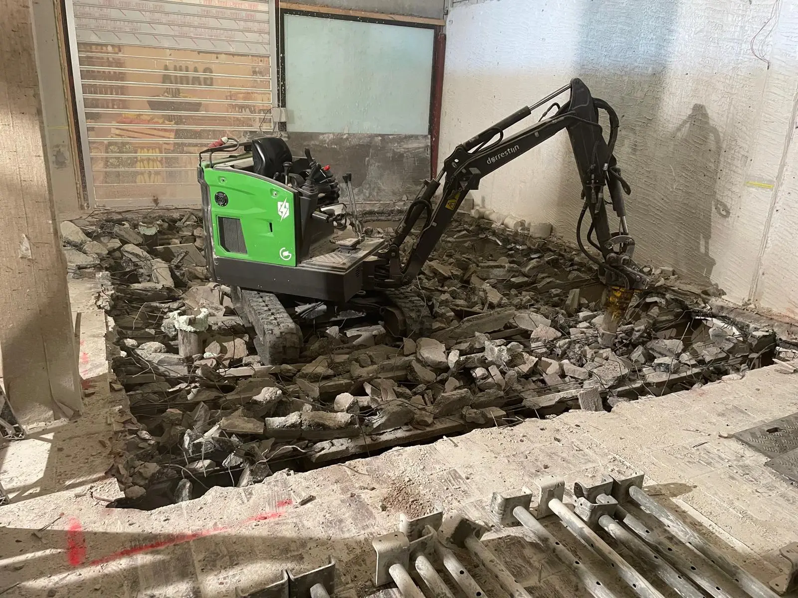 Betonvloer slopen met behulp van een minikraan